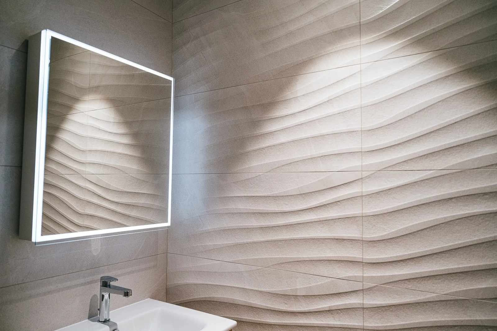 Détail d’un mur texturé et d’un miroir dans une salle d’eau